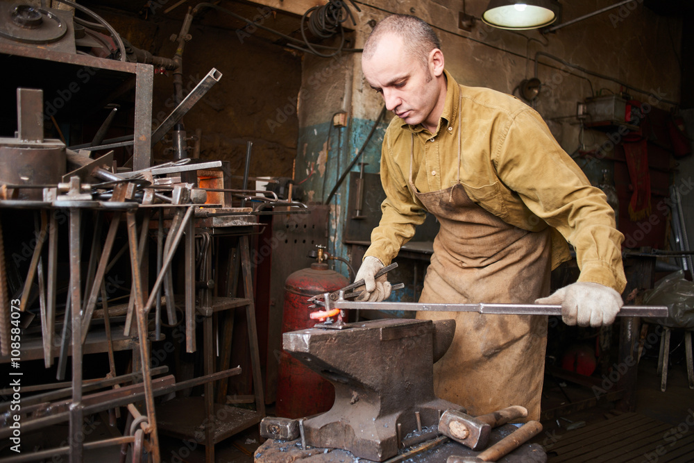 The blacksmith in the production process of metal products handmade in the workshop The blacksmith in the production process of metal products handmade in the workshop
