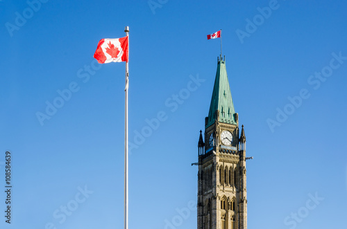 Close up of peace tower (parliament building) in Ottawa, Canada, with canadian, flags photo