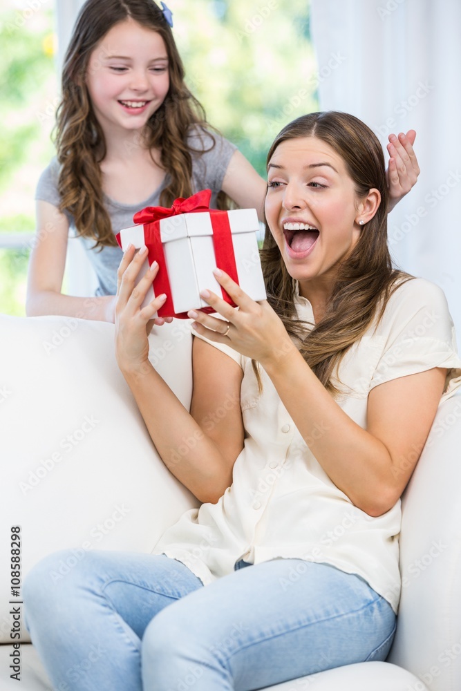 Woman surprised looking at gift given by daughter Woman surprised looking at gift given by daughter