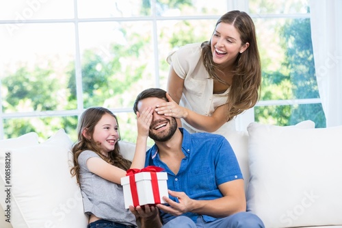 Man surprised with gift in sofa 