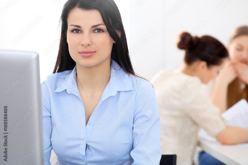 Young businesswoman sitting at desk and working Young businesswoman sitting at desk and working