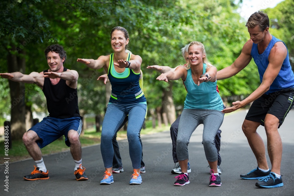 Obraz premium Fitness class doing squat sequence