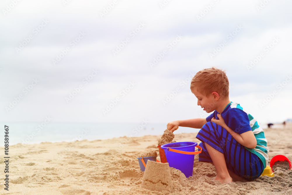 little boy play with sand on summer beach little boy play with sand on summer beach