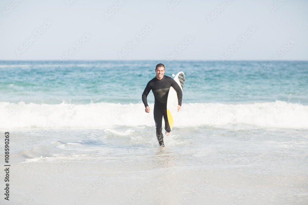 Surfer running on the beach with a surfboard Surfer running on the beach with a surfboard