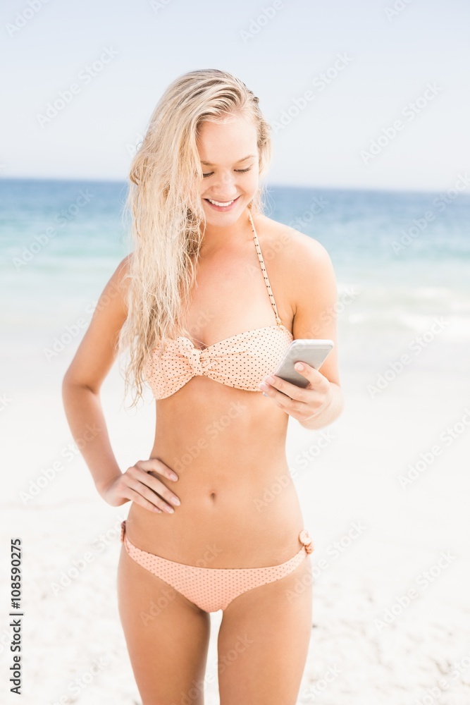 Pretty woman in bikini using mobile phone