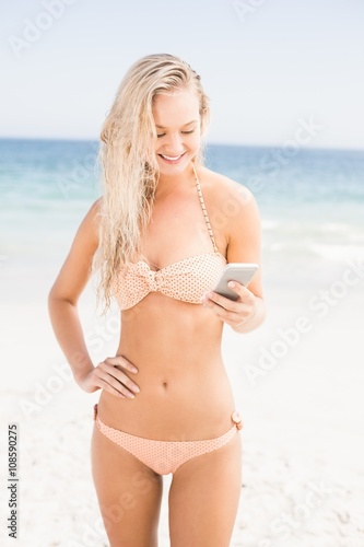 Pretty woman in bikini using mobile phone