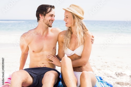 Young couple sitting and talking on the beach