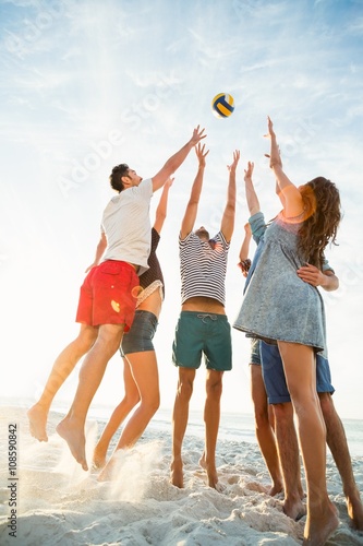 Foto Friends trying to catch volley ball