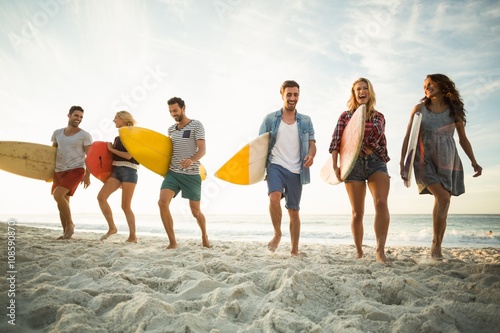 Friends holding surfboard on the beach
