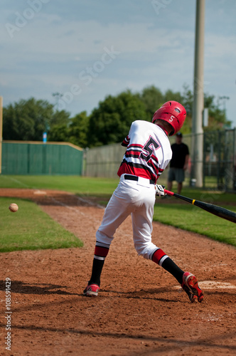 Youth baseball boy swinging bat.