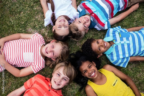 Happy children lying on grass