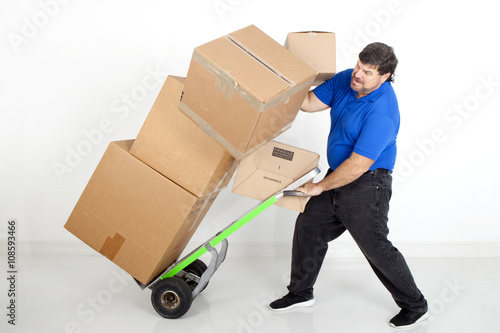 Man moving boxes with a hand cart or dollie and dropping them photo