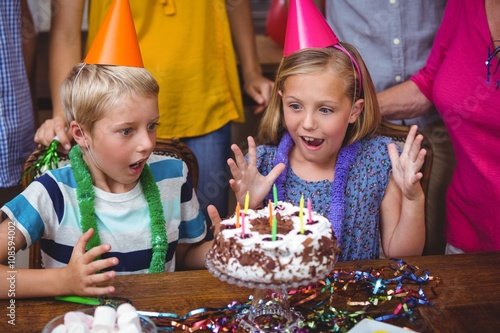 Shocked siblings with birthday cake 