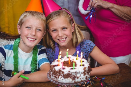 Portrait of cheerful siblings with family celebrating birthday 