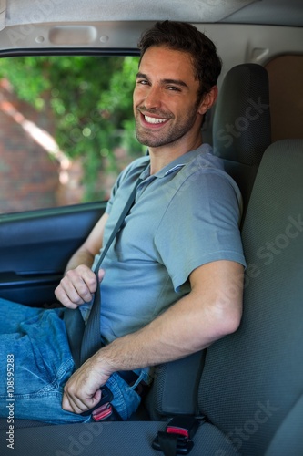 Foto Handsome driver fastening car seat belt