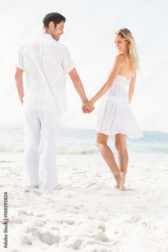 Couple holding hands at the beach