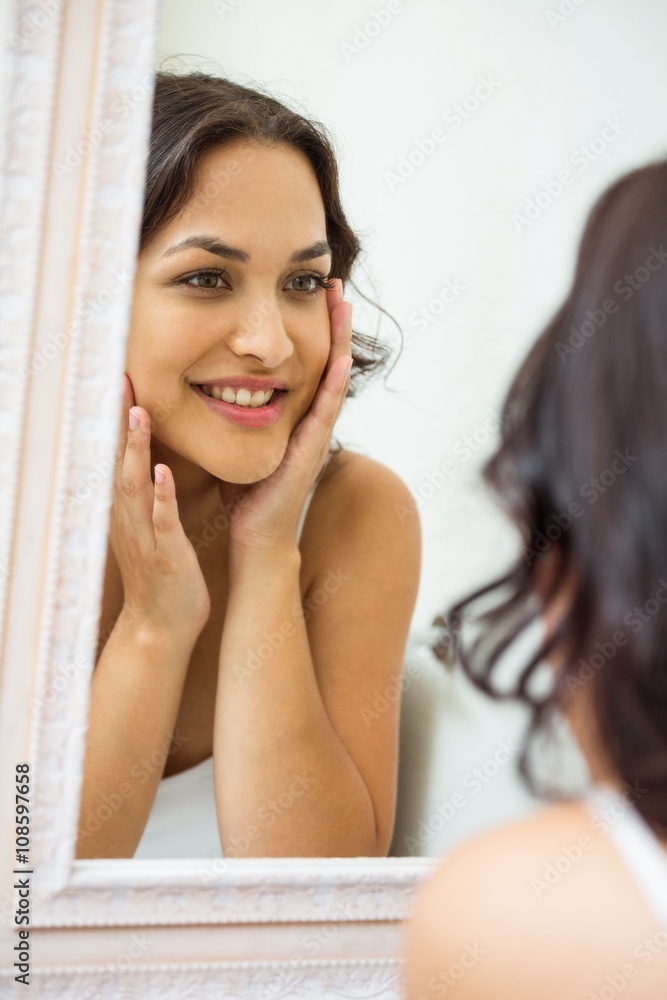 Obraz premium Young woman looking in mirror of bathroom