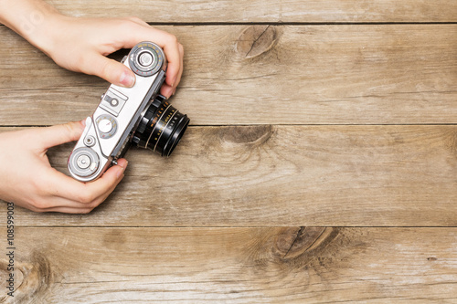 woman's hands holding a retro camera