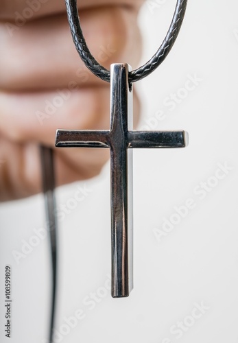 Faith and religion concept. Metallic cross or crucifix in hand.