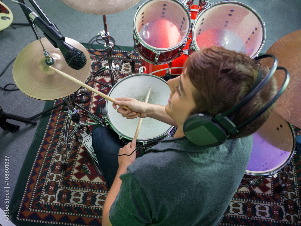 Fototapeta premium Smiling Male Drummer Wearing Headphones While Performing