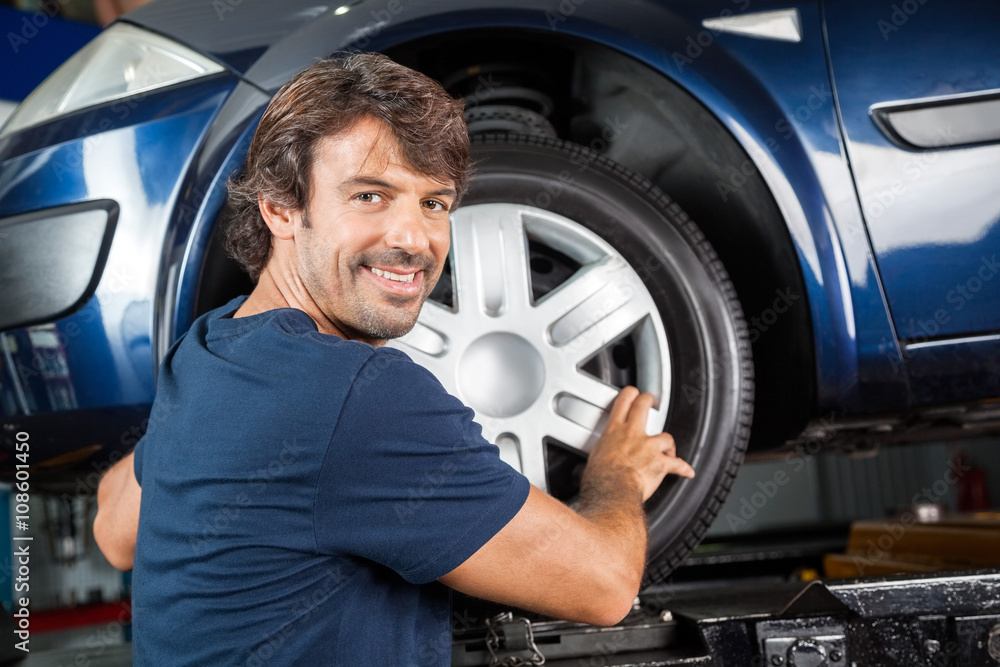 Confident Mechanic Fixing Alloy To Tire Confident Mechanic Fixing Alloy To Tire