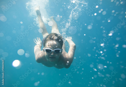 The boy in the sea swimming under water