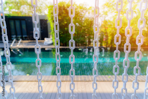 Close-up The white chain curtain and blur swimming pool background