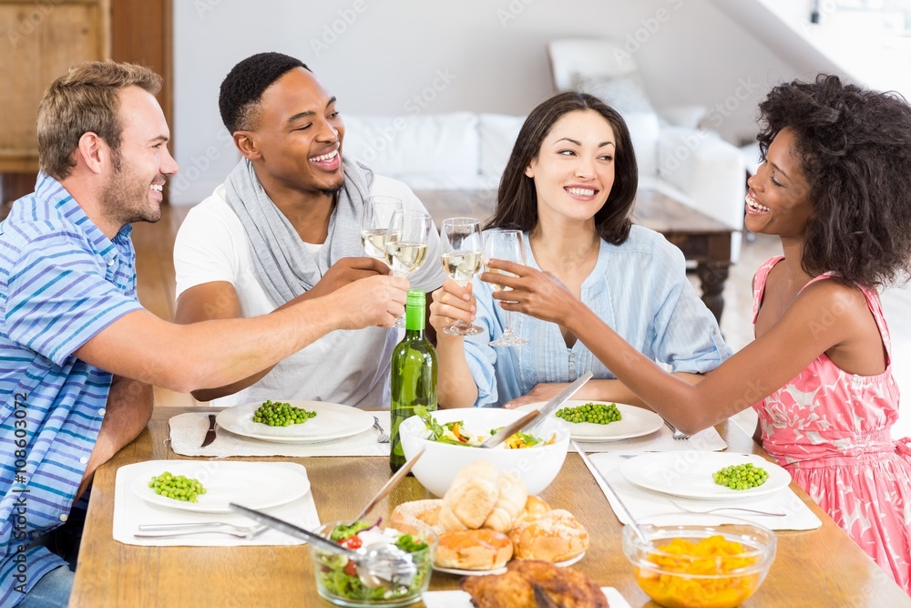 Friends toasting wine glasses while having a meal