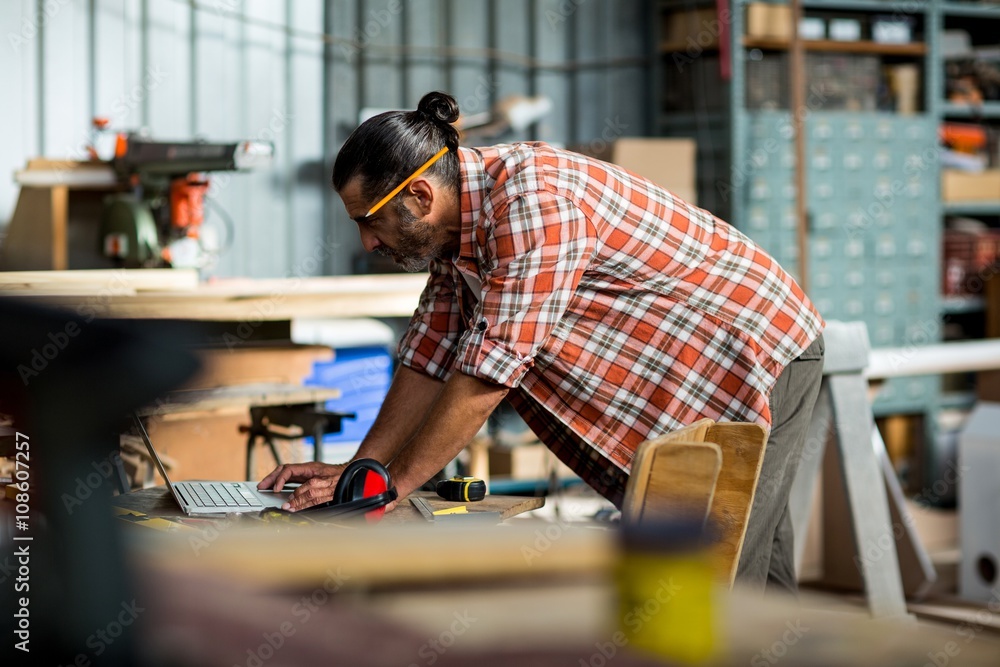 Carpenter using laptop Carpenter using laptop