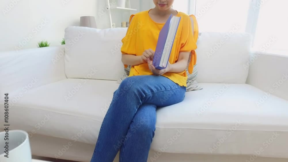 smiling young asian woman reading book at home smiling young asian woman reading book at home