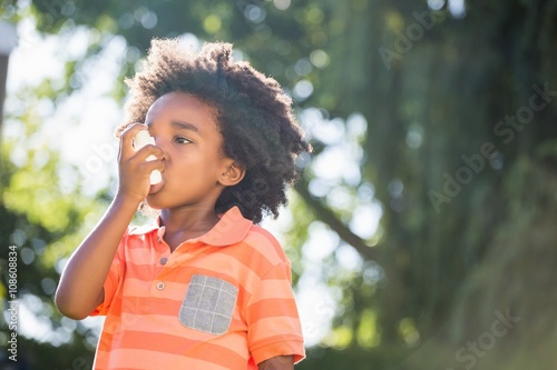 Cute mixed-race boy using a asthmatic spray