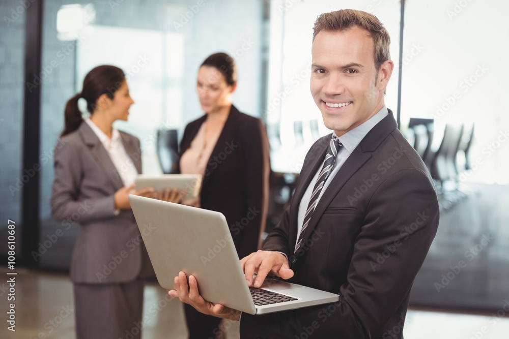 Portrait of businessman holding laptop in the office Portrait of businessman holding laptop in the office