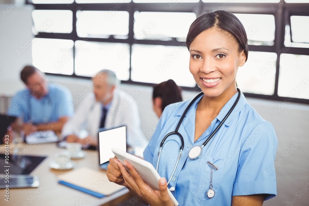 Happy female doctor using digital tablet in conference room Happy female doctor using digital tablet in conference room