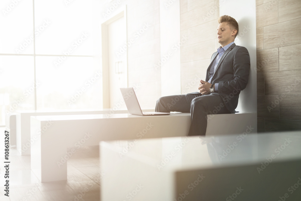 Business man sitting alone on a bench with laptop Business man sitting alone on a bench with laptop