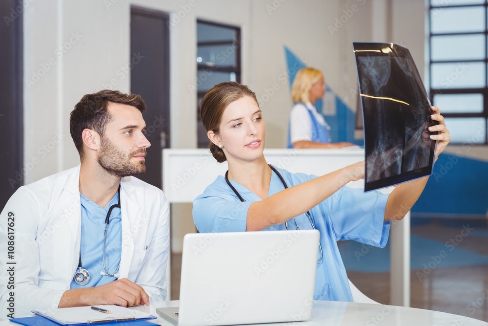 Obraz premium Female doctor examining X-ray with colleague 