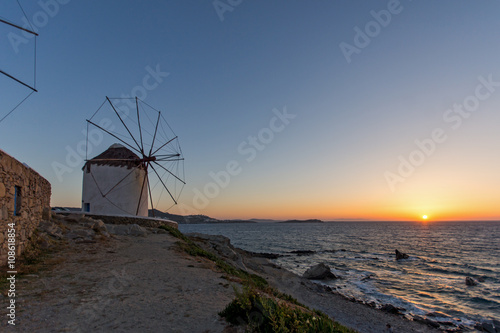 Sunset of White windmills and Aegean sea on the island of Mykonos, Cyclades, Greece