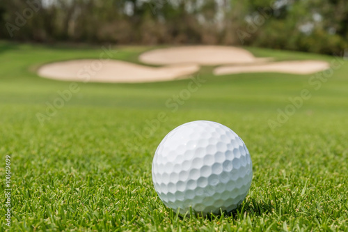 Close up the Golf ball on grass with blurred green course backgr