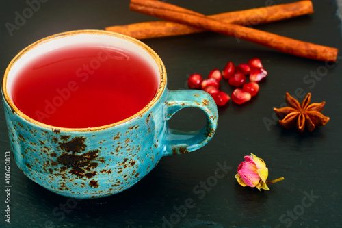 Red Tea with beautiful cup, decorated with cinnamon and pomegran photo