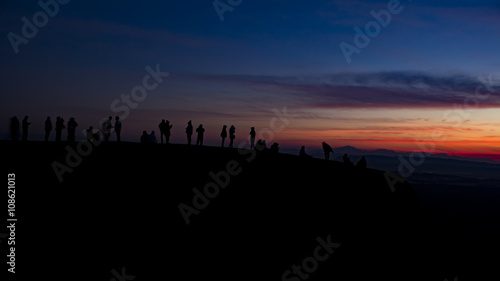 silhouette group of young people waiting sunrise