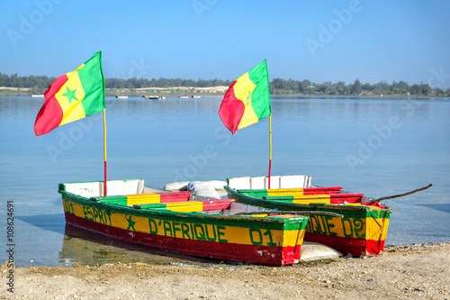 Две цветные лодки с флагом Сенегала на берегу соленого озера Retba