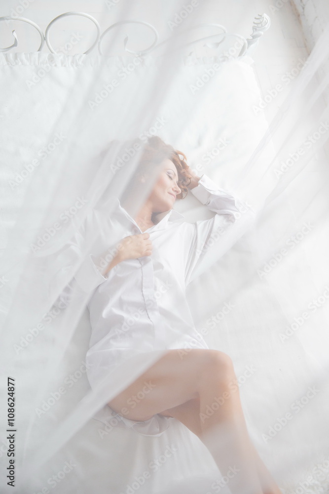 happy girl lies on a bed. Happy young woman lying on the bed with raised legs up. girl in a white men's shirt
happy girl lies on a bed. Happy young woman lying on the bed with raised legs up. girl in a white men's shirt