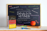Blackboard in a German classroom with the message LEARN GERMAN and some text