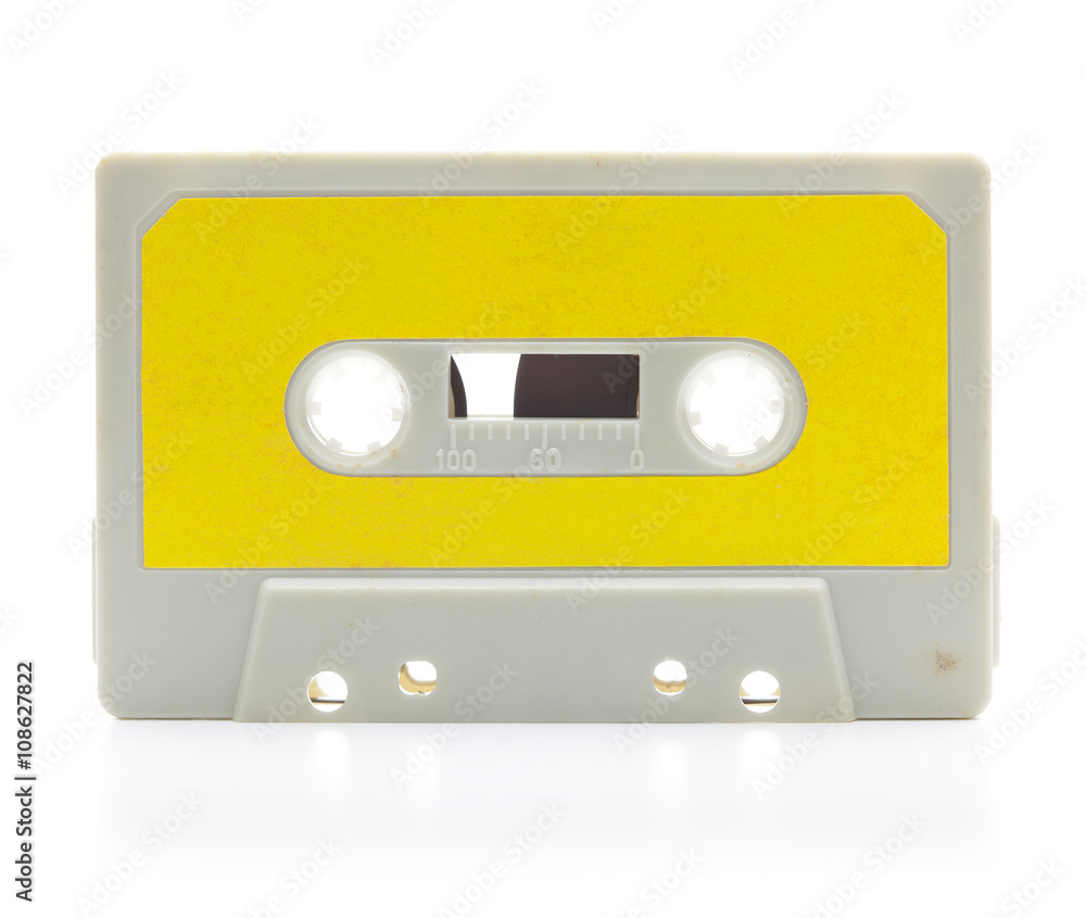 Early 70's cassette tape isolated on white with slight reflection. Yellow label.