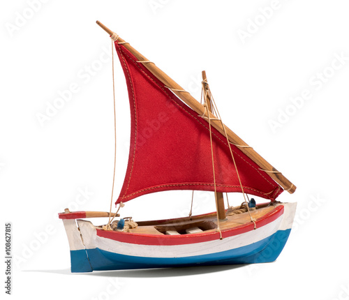 Wooden handmade toy boat with a red sail photo