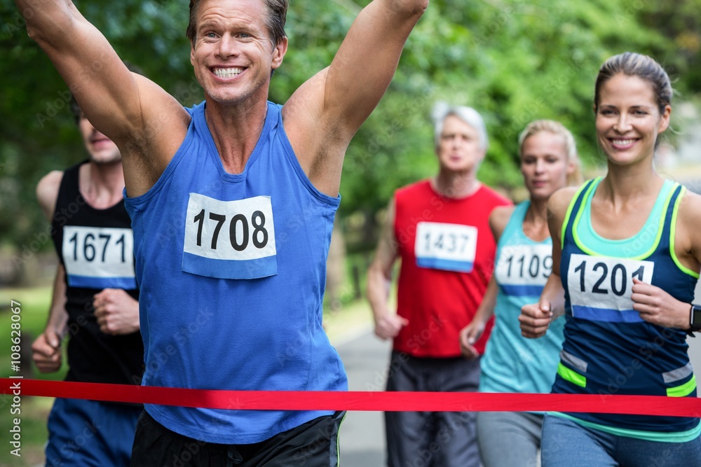 Fototapeta premium Marathon male athlete crossing the finish line