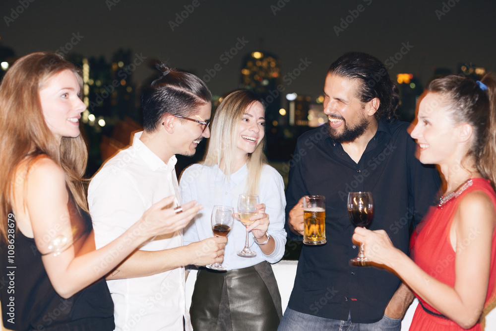 Happy people on rooftop party. Cityscape view at night. Happy people on rooftop party. Cityscape view at night.
