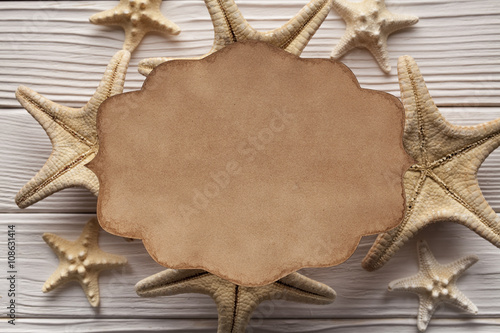 Blank paper label and starfish on wooden background
