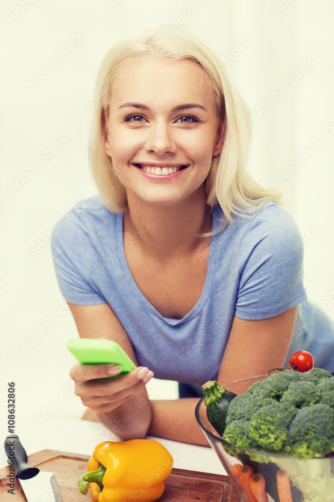 smiling woman with smartphone cooking vegetables smiling woman with smartphone cooking vegetables