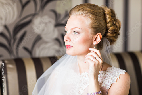 Beautiful bride with fashion wedding hairstyle. Closeup portrait of young gorgeous bride. 