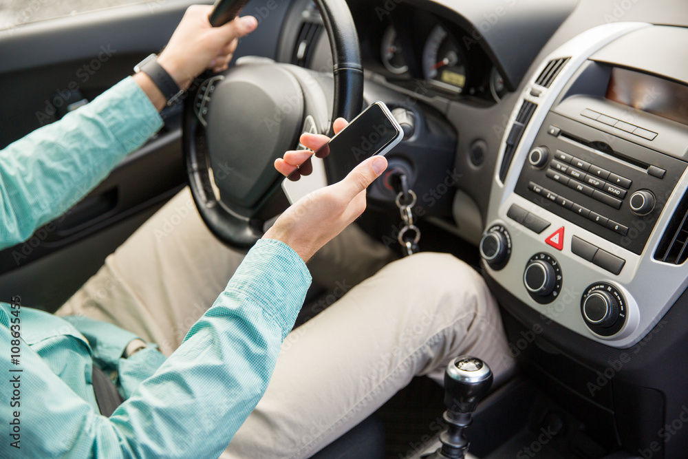 close up of man with smartphone driving car close up of man with smartphone driving car